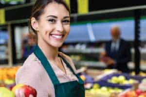 grocery store employee holding apple